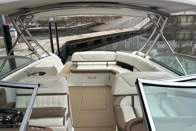 Slide: The Image of 2014 Cobalt 302 boat interior with white and beige seating at a dock. - 6