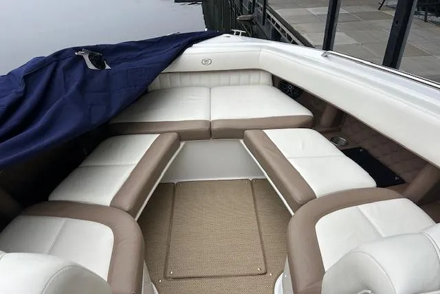 Slide: The Image of 2014 Cobalt 302 boat interior with white and beige seating, partially covered. - 7