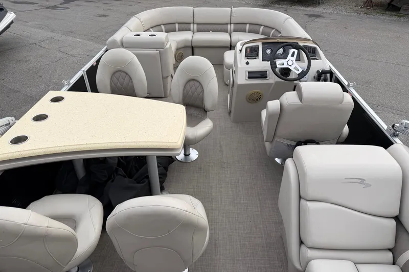 Slide: The Image of 2016 Bennington SXP 24 SSBXP pontoon boat interior with beige seating and steering console. - 7