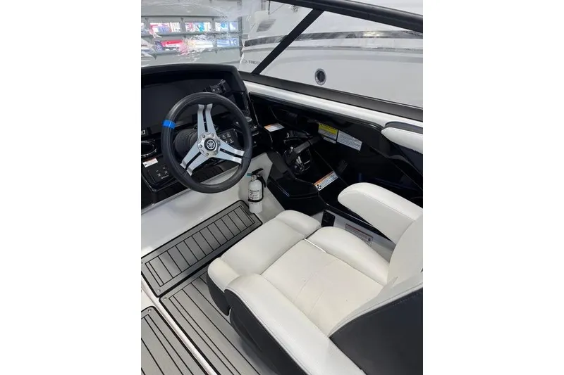 Slide: The Image of 2020 Yamaha Boats 242SE cockpit with steering wheel and white seating. - 14
