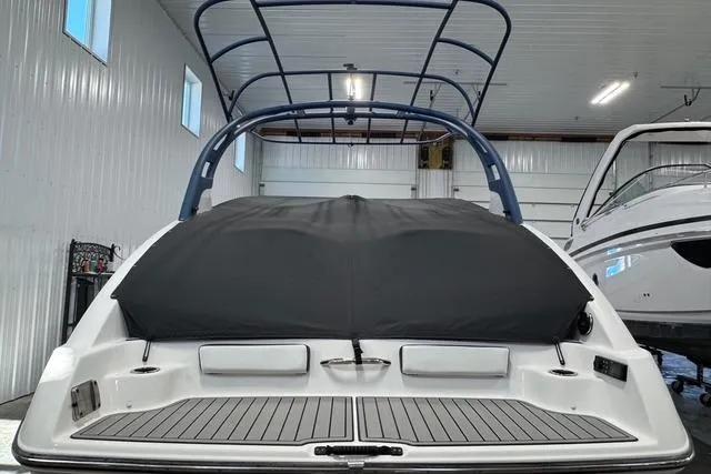 Slide: The Image of 2020 Yamaha Boats 242SE in storage, rear view with cover and wakeboard tower. - 4