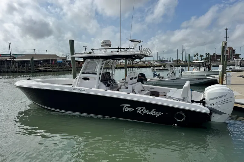 Slide: The Image of 2018 Fountain 34 Center Console boat docked in marina, featuring sleek design and Mercury engines. - 1