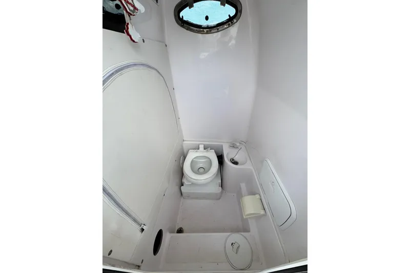 Slide: The Image of 2018 Fountain 34 Center Console boat bathroom with toilet and porthole window. - 11
