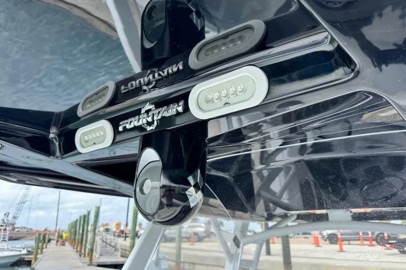 Slide: The Image of 2018 Fountain 34 Center Console boat detail with logo and dock background. - 15
