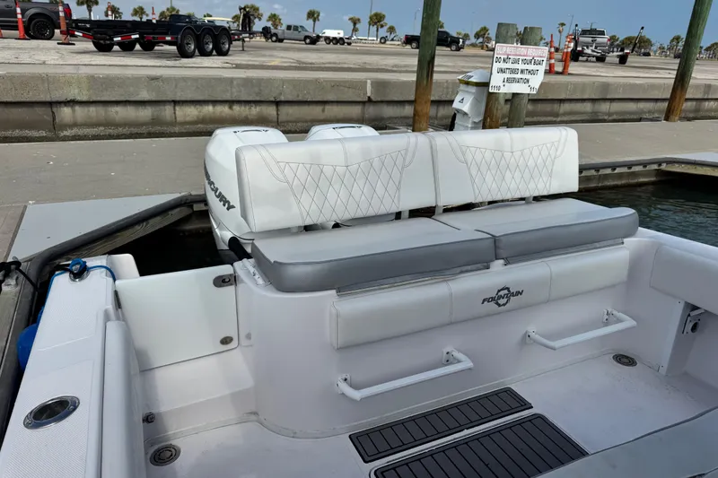 Slide: The Image of 2018 Fountain 34 Center Console boat interior with seating and dock view. - 23