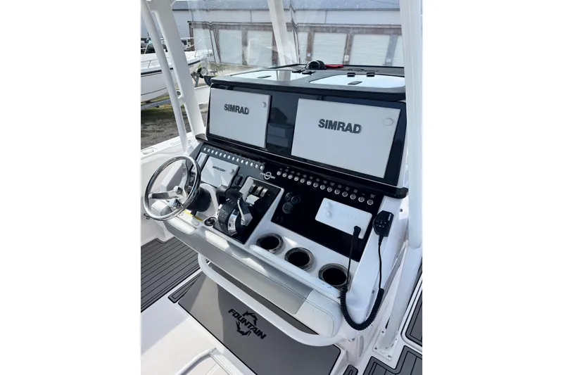Slide: The Image of 2018 Fountain 34 Center Console boat dashboard with Simrad displays and steering wheel. - 3