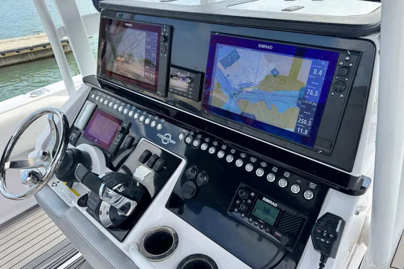 Slide: The Image of 2018 Fountain 34 Center Console boat dashboard with navigation screens and controls. - 5