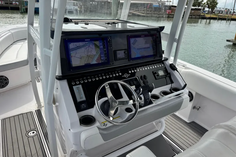 Slide: The Image of 2018 Fountain 34 Center Console boat with advanced navigation system and sleek steering wheel. - 7