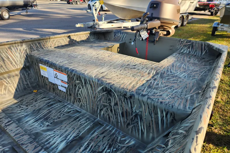 Slide: The Image of 2026 Tracker Grizzly 15 Jon boat with camouflage pattern and outboard motor. - 4