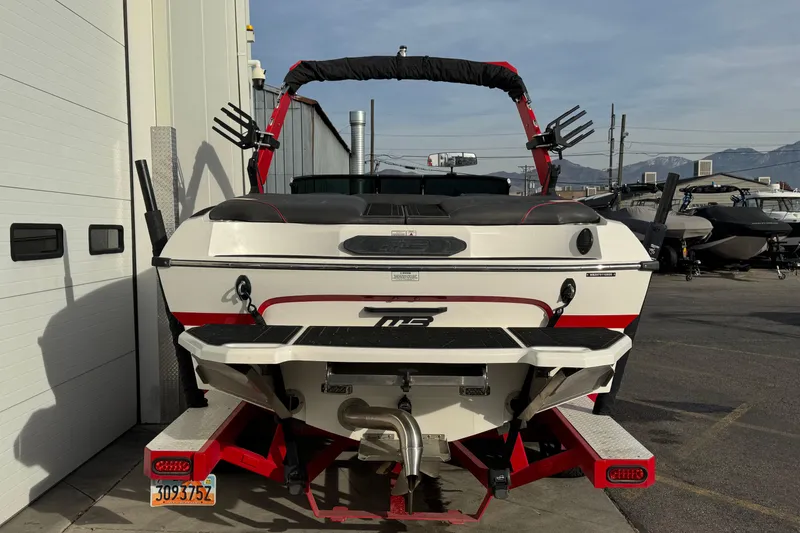 Slide: The Image of 2020 MB B52 23 Classic boat, rear view, parked outdoors near other boats. - 2