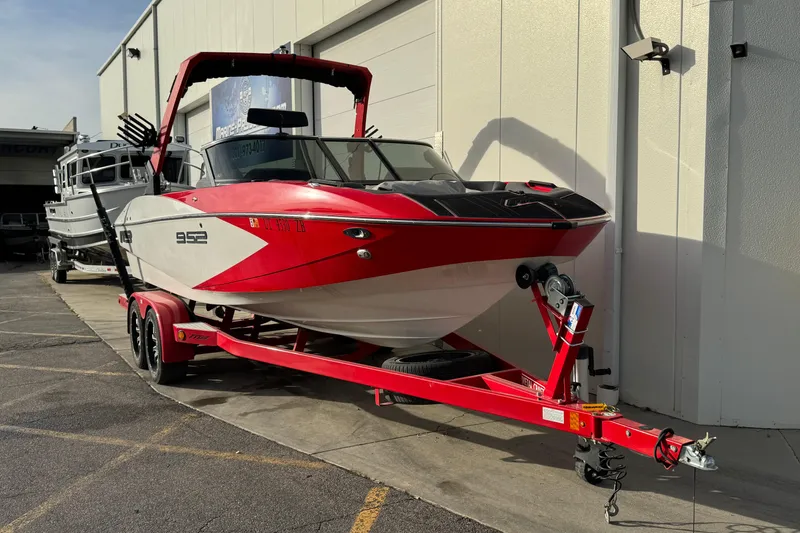 Slide: The Image of Red and white 2020 MB B52 23 Classic boat on trailer, parked outside. - 3