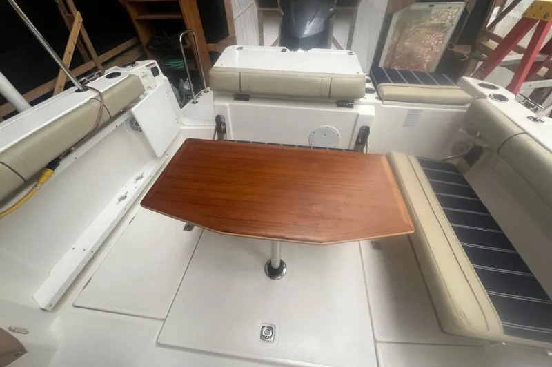 Slide: The Image of 2020 Ranger Tugs R-27 Luxury Edition Tug interior with wooden table and cushioned seating. - 15