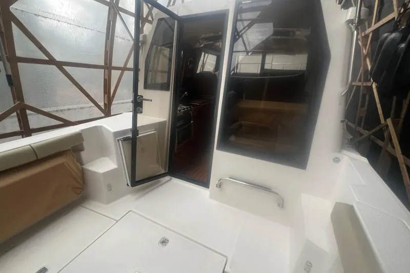 Slide: The Image of 2020 Ranger Tugs R-27 Luxury Edition Tug interior with open door and seating area. - 19