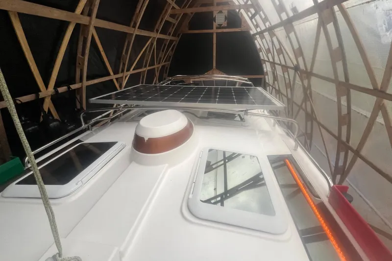 Slide: The Image of 2020 Ranger Tugs R-27 Luxury Edition Tug with solar panels under a wooden shelter. - 26