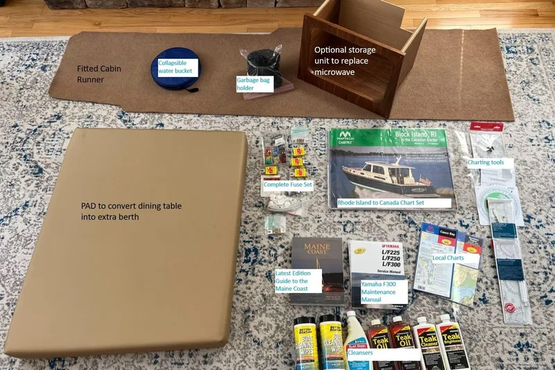 Slide: The Image of 2020 Ranger Tugs R-27 accessories: cabin runner, storage unit, chart set, maintenance manuals, and cleaning supplies. - 31