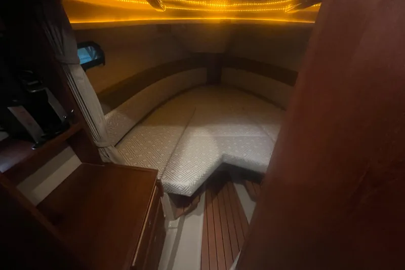 Slide: The Image of 2020 Ranger Tugs R-27 Luxury Edition Tug interior cabin with cozy lighting and wood accents. - 4