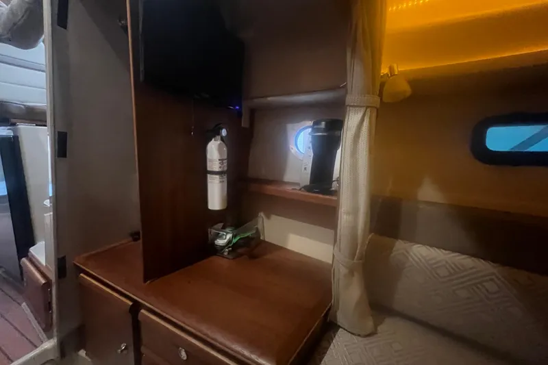 Slide: The Image of 2020 Ranger Tugs R-27 interior with wooden cabinetry, fire extinguisher, and coffee maker. - 5