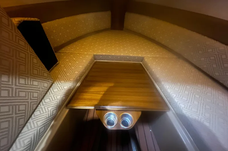 Slide: The Image of 2020 Ranger Tugs R-27 Luxury Edition Tug interior with wood table and patterned upholstery. - 6