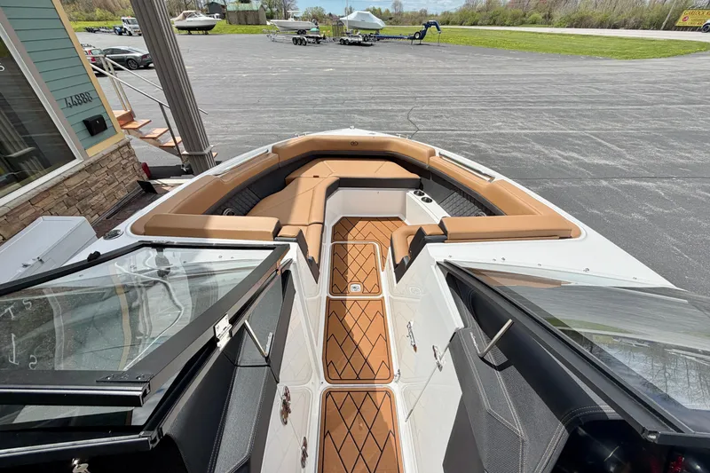 Slide: The Image of 2026 Cobalt R8 Outboard boat interior with tan seating and wood-patterned flooring. - 23