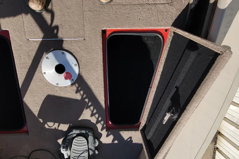 Slide: The Image of 2007 Triton DV 176 Mag boat interior with open storage compartment and pedal. - 16