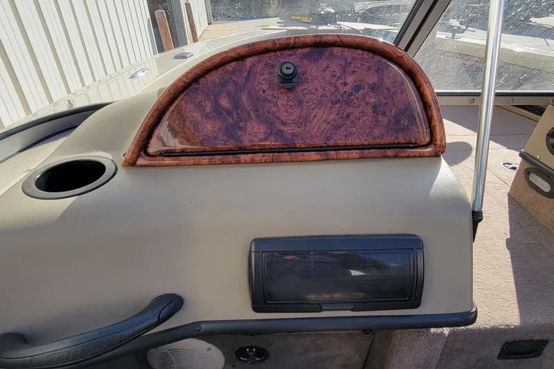 Slide: The Image of 2007 Triton DV 176 Mag boat dashboard with wood paneling and storage compartments. - 21