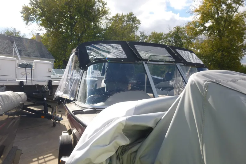 Slide: The Image of 2007 Triton DV 176 Mag boat with protective cover, parked outdoors. - 24