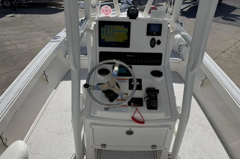 Slide: The Image of 2021 Pathfinder 2500 Hybrid boat console with steering wheel and navigation equipment. - 2