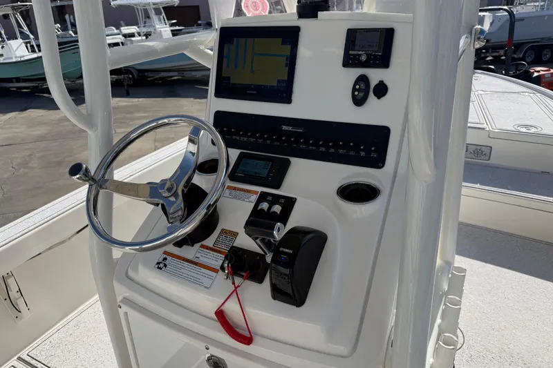 Slide: The Image of Control panel of a 2021 Pathfinder 2500 Hybrid boat with steering wheel and navigation instruments. - 3