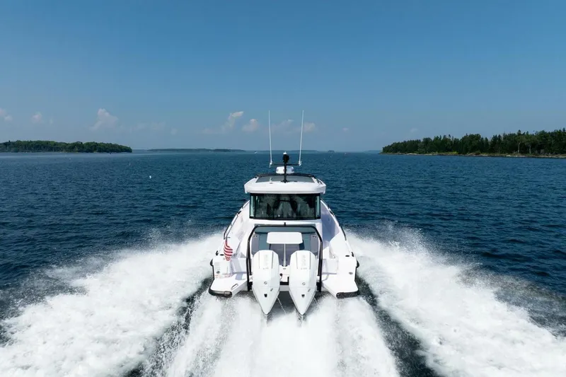 Slide: The Image of Axopar 37 U-Sofa 2026 cruising on open water, rear view. - 9
