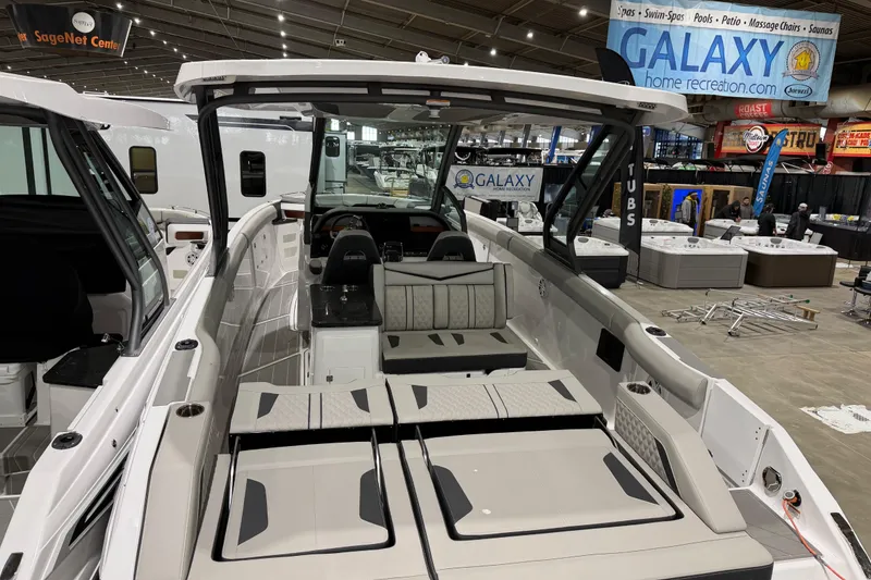 Slide: The Image of 2026 Monterey Elite 30 OB boat interior with seating and helm, parked outdoors. - 10