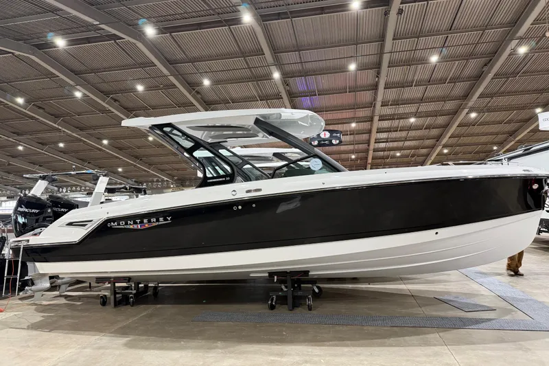 Slide: The Image of 2026 Monterey Elite 30 OB boat on trailer under clear blue sky. - 8