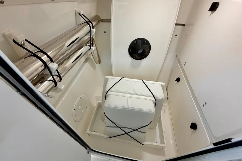 Slide: The Image of Interior of 2026 Pursuit DC 266 Dual Console boat, featuring storage and seating area. - 22