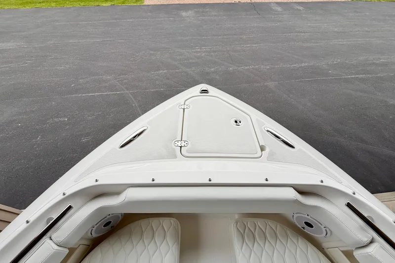 Slide: The Image of Bow view of 2026 Pursuit DC 266 Dual Console boat, featuring sleek design and storage hatch. - 27