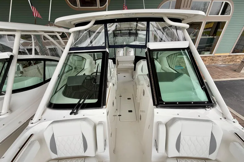 Slide: The Image of 2026 Pursuit DC 266 Dual Console boat interior with white seating and windshield. - 28