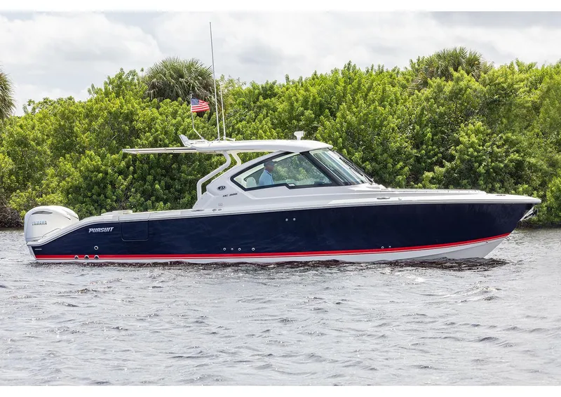 Slide: The Image of Manufacturer Provided Image: 2025 Pursuit DC 326 Dual Console boat on water, lush greenery background. - 1