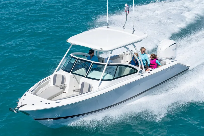 Slide: The Image of Manufacturer Provided Image: 2025 Pursuit DC 246 Dual Console boat cruising on clear blue water. - 2