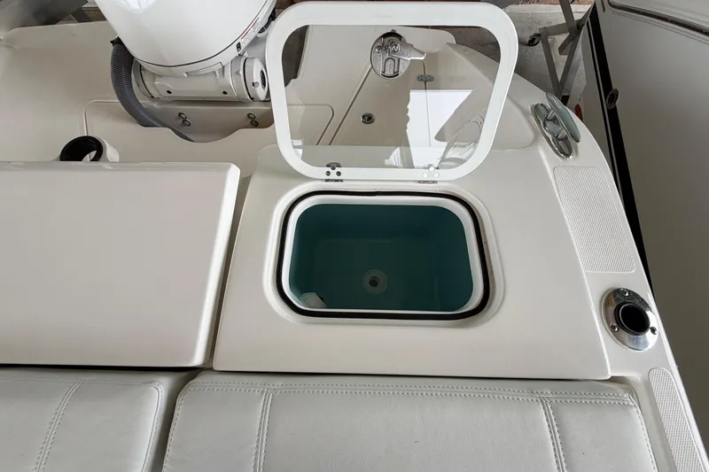 Slide: The Image of 2026 Pursuit DC 246 Dual Console boat with open storage compartment. - 22