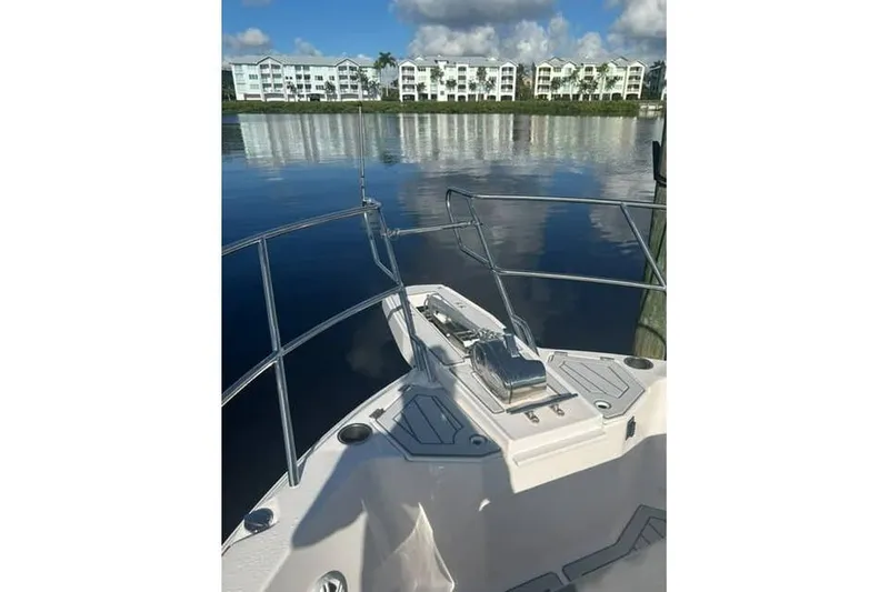 The Image of Bow view of 2026 Solara S-310 SB boat on calm water, with buildings in background. - 1