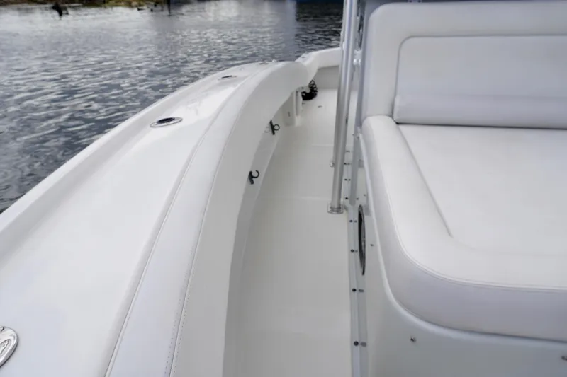 Slide: The Image of 2019 Dusky 33 boat interior with white seating and sleek design on calm water. - 15
