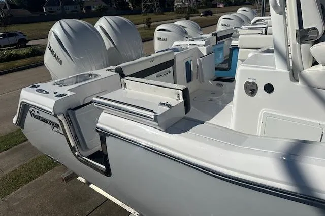 Slide: The Image of 2026 Tidewater 282 CC Adventure boat with Yamaha engines, docked outdoors. - 2