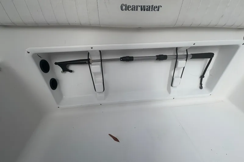 Slide: The Image of 2012 Clearwater 2100 WA boat interior with storage compartment and fishing rod holder. - 17