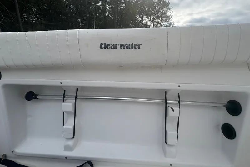 Slide: The Image of 2012 Clearwater 2100 WA boat interior with rod holders and padded seating. - 7
