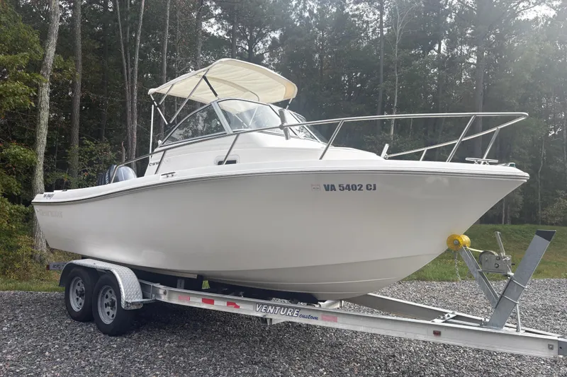 Slide: The Image of 2012 Clearwater 2100 WA boat on trailer, parked in wooded area. - 10