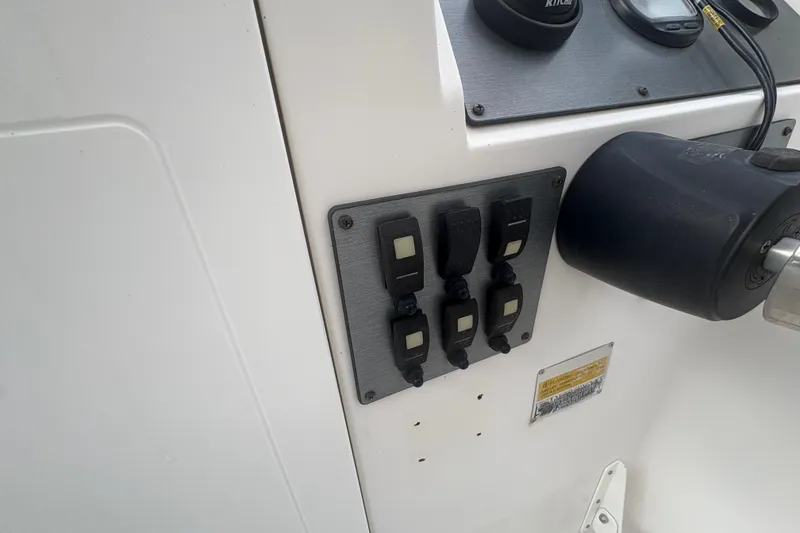 Slide: The Image of Control panel on a 2012 Clearwater 2100 WA boat dashboard with switches and gauges. - 14