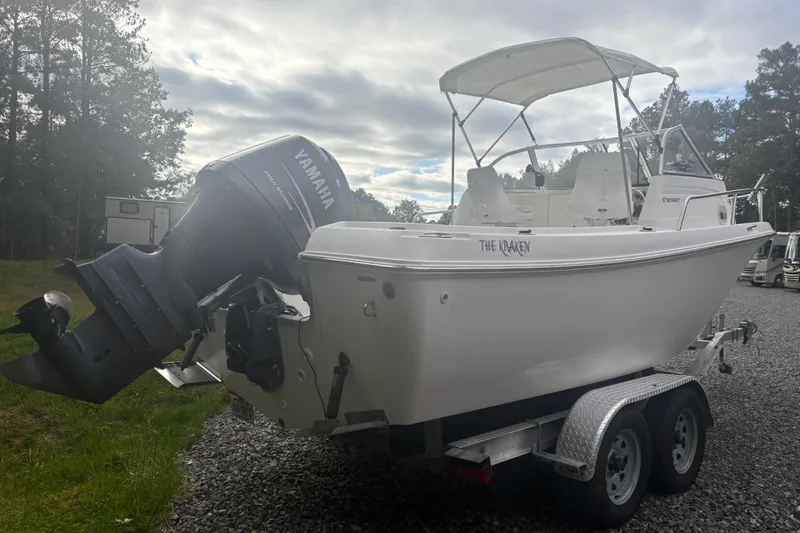 Slide: The Image of 2012 Clearwater 2100 WA boat on trailer with Yamaha outboard motor, parked outdoors. - 4