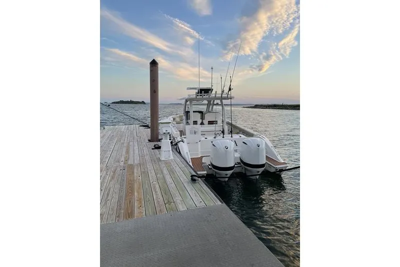 Slide: The Image of 2019 Pursuit S 328 Sport boat docked at sunset with dual engines. - 10