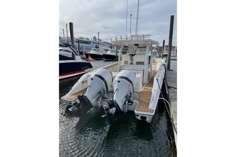 Slide: The Image of 2019 Pursuit S 328 Sport boat docked with dual outboard engines. - 3