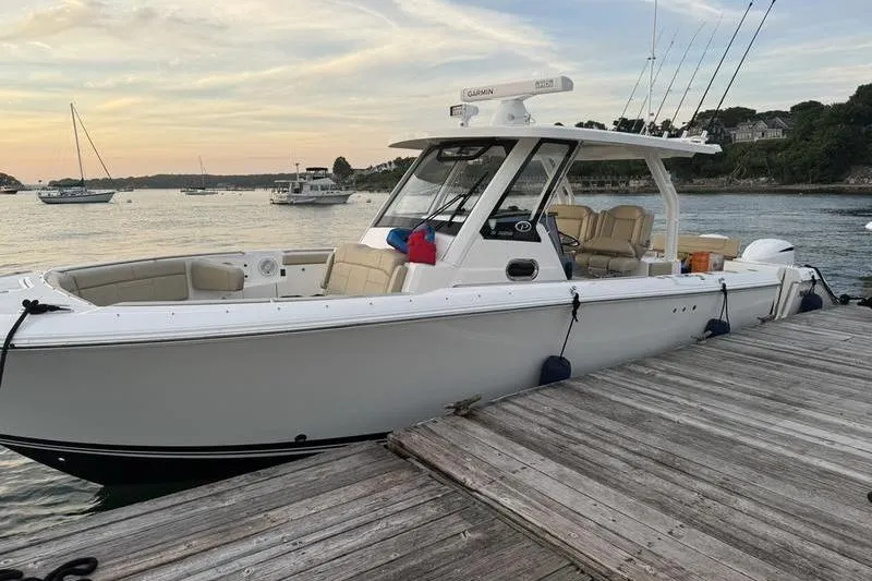 Slide: The Image of 2019 Pursuit S 328 Sport boat docked at a marina during sunset. - 4