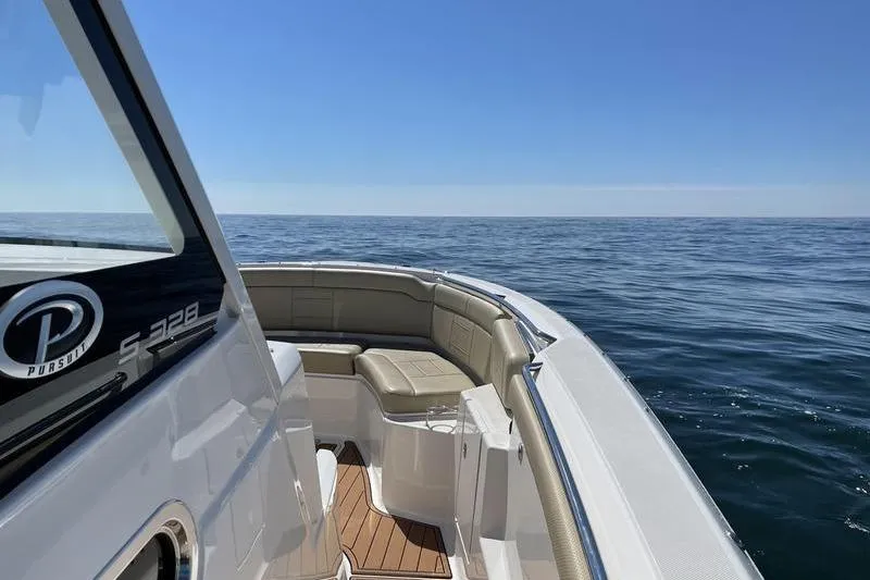 Slide: The Image of 2019 Pursuit S 328 Sport boat on open sea, clear sky, luxurious seating. - 5