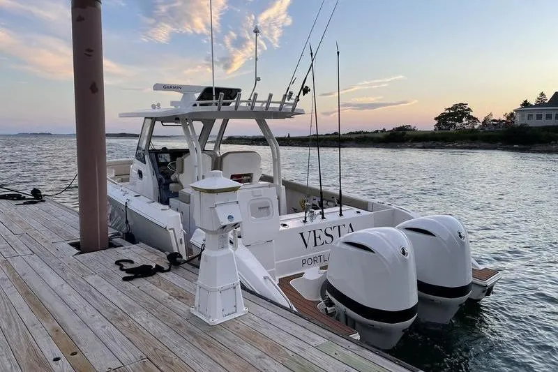 Slide: The Image of 2019 Pursuit S 328 Sport boat docked at sunset with dual engines. - 6